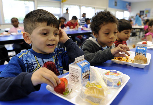 In this Tuesday, April 29, 2014 photo, Biden Arias-Romers, 5, left, and Nathaniel Cossio-Boatwright, 6, eat lunch at the Patrick Henry Elementary School in Alexandria, Va. Starting next school year, pasta and other grain products in schools will have to be whole-grain rich, or more than half whole grain. The requirement is part of a government effort to make school lunches and breakfasts healthier. (AP Photo/Susan Walsh) CREDIT: AP PHOTOS
