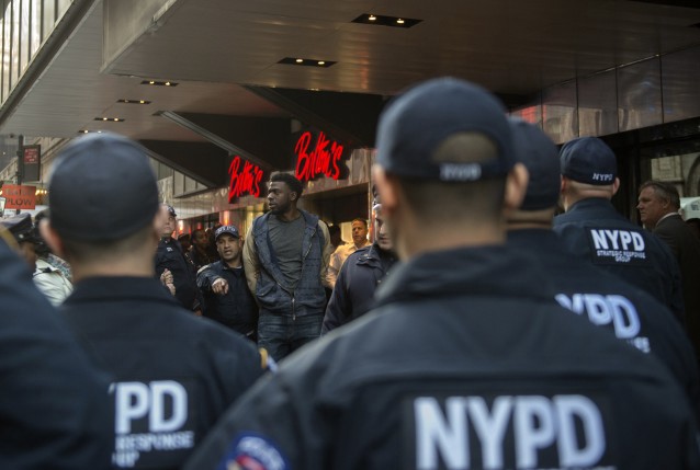 A protester is taken away in handcuffs by police from the Grand Hyatt Hotel. CREDIT: AP Photo/Bryan R. Smith