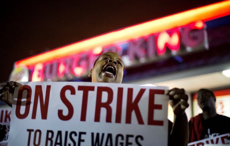 A Burger King employee protesting for higher wages in 2015 CREDIT: AP PHOTO/DAVID GOLDMAN