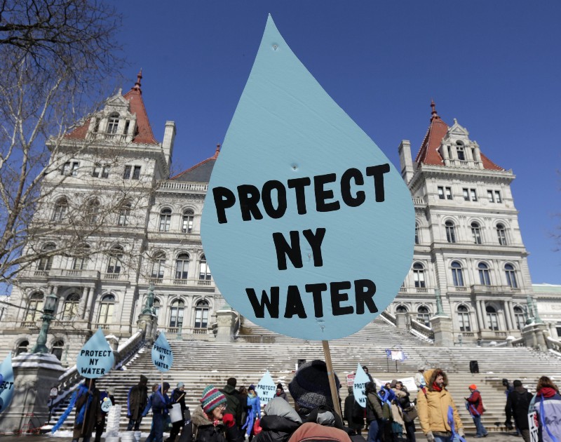 A man carries a sign before a rally opposing the Constitution Pipeline outside the state Capitol on Tuesday, April 5, 2016, in Albany, N.Y. CREDIT: AP PHOTO/MIKE GROLL