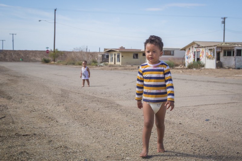 Alberto Jiménez, 3, walks back to his dad who is waiting near the porch of their trailer home located just a block away from the Salton Sea. CREDIT: Alejandro Davila Fragoso