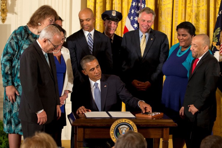 Bi activist Faith Cheltenham, second from right, stood by President Obama as he signed his executive order protecting LGBT employees of federal contractors. CREDIT: AP Photo/Jacquelyn Martin