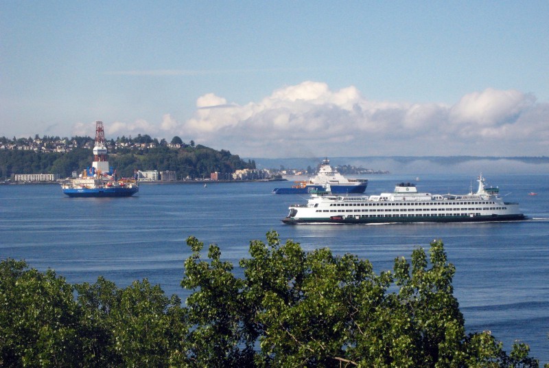 Ships bringing oil drilling equipment to Alaska, left, pass through Seattle’s Elliott Bay on Wednesday, June 27, 2012, as a Washington State Ferry passes on its way into Seattle. Arctic drilling has been a contentious issue for environmentalists. CREDIT: AP PHOTO/DONNA GORDON BLANKINSHIP