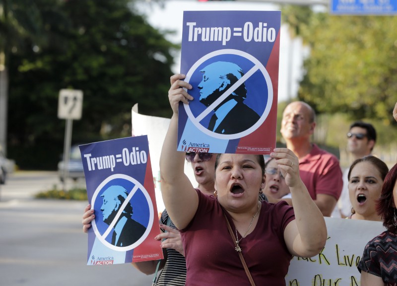 Berta Sandes, 38, of Miami, an undocumented immigrant from Nicaragua, holds a sign which translates to “Trump Equals Hate” during a protest against Republican presidential candidate Donald Trump outside of the Trump National Doral golf resort, Monday, March 14, 2016, in Doral, Fla. Voters go to the polls in Florida Tuesday for the primary election. (AP Photo/Lynne Sladky) CREDIT: AP PHOTO/LYNNE SLADKY