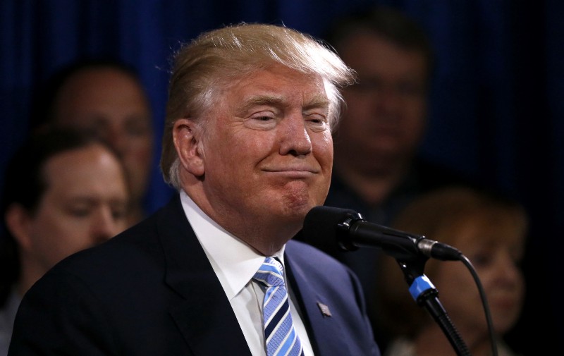 Republican presidential candidate Donald Trump smiles as he stands with 22 delegates from North Dakota to the Republican National Convention, who are the core of delegates that elevated Trump over the 1237 needed for the GOP’s presidential nomination, Thursday, May 26, 2016, in Bismarck, N.D. CREDIT: AP PHOTO/CHARLES REX ARBOGAST