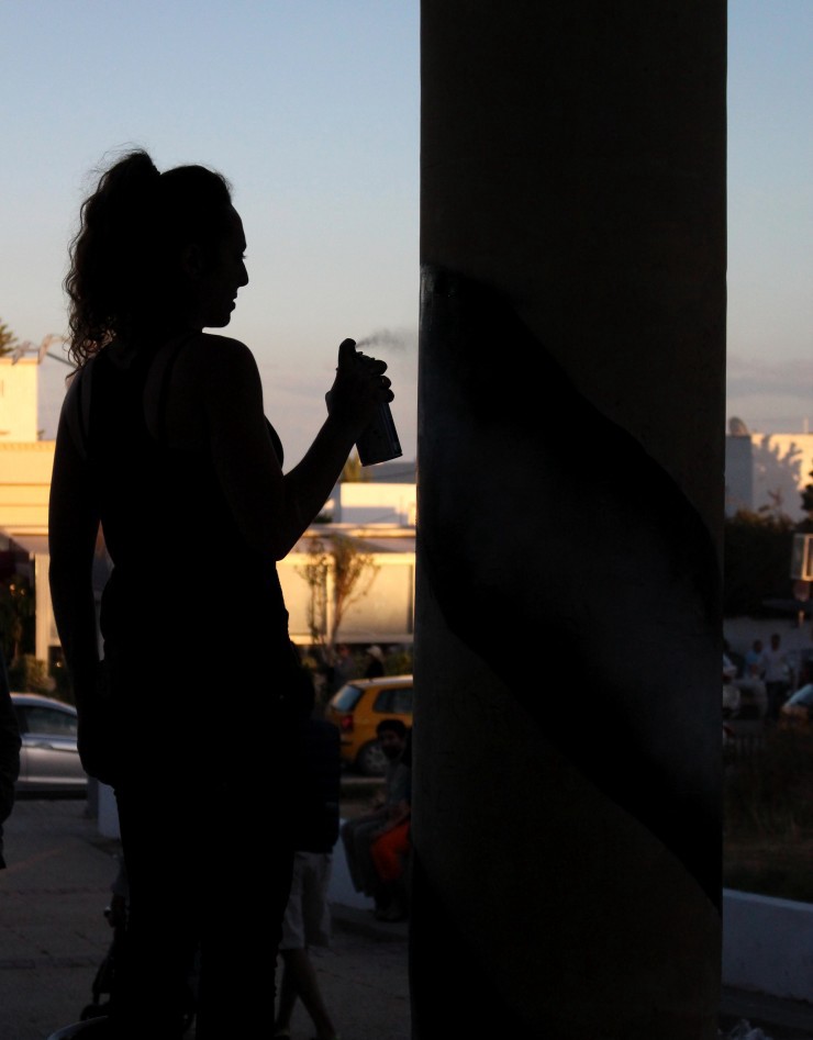 Woman spray paints a column during the Chouftohounna Feminist Art Festival in Tunis, 15 May 2016. CREDIT: Erin Kilbride