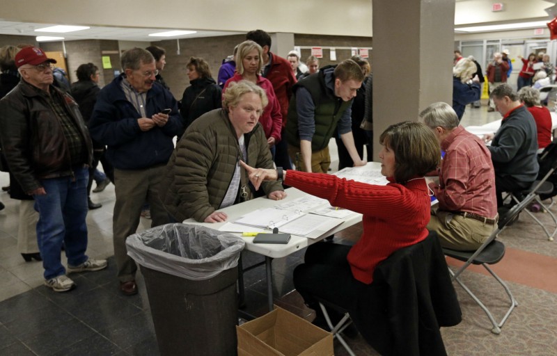 A party volunteer steers a woman to her precinct meeting room as Republican caucus goers gathered at Bloomington Jefferson High School Tuesday, March 1, 2016, in Bloomington, Minn. CREDIT: AP PHOTO/JIM MONE