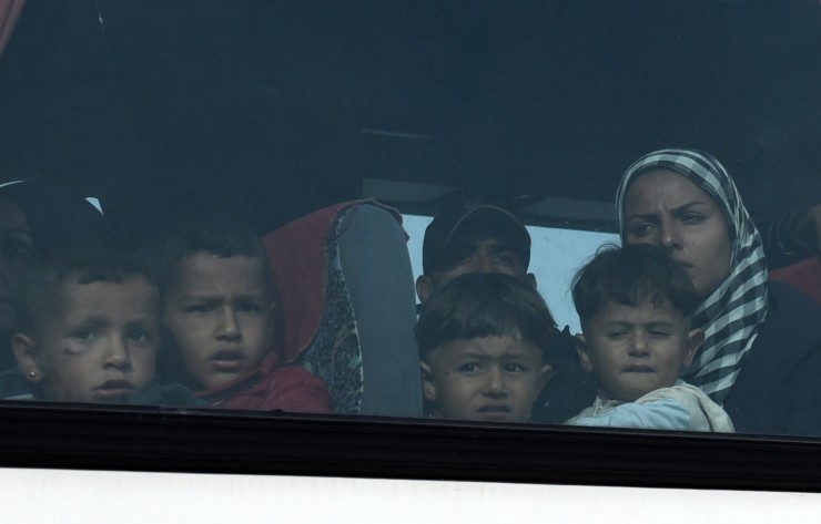A bus moves a migrant family to an organized camp during an operation to evacuate the makeshift refugee camp at the Greek-Macedonian border near the northern Greek village of Idomeni, Tuesday, May 24, 2016. CREDIT: AP Photo/Giannis Papanikos