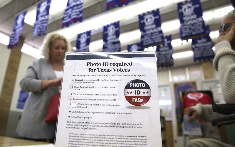 A sign tells voters of voter ID requirements before participating in the primary election at Sherrod Elementary school in Arlington, Texas, Tuesday, March 1, 2016. CREDIT: AP PHOTO/LM OTERO