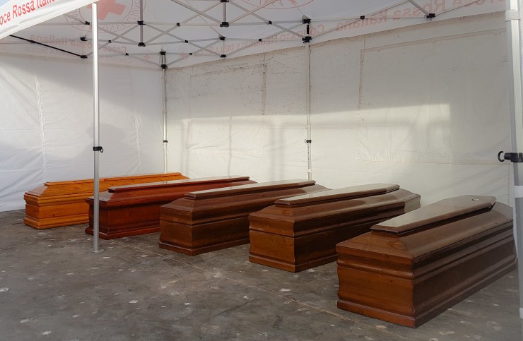 Five coffins lie on the ground after being disembarked from the Italian Navy ship Bettica, at the Sicilian Porto Empedocle harbor, Italy, Thursday, May 26, 2016. CREDIT: AP Photo/Francesco Malavolta