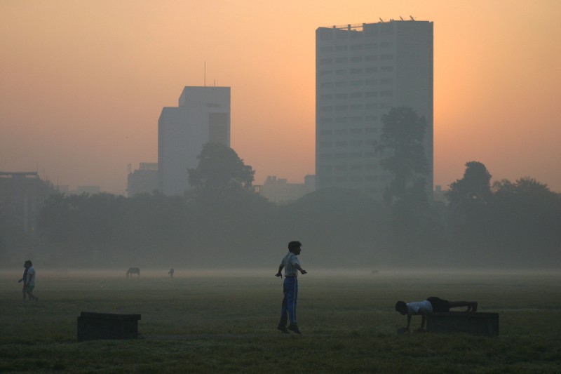 Two young men exercise on a foggy morning in Calcutta, India. CREDIT: AP PHOTO/SUCHETA DAS
