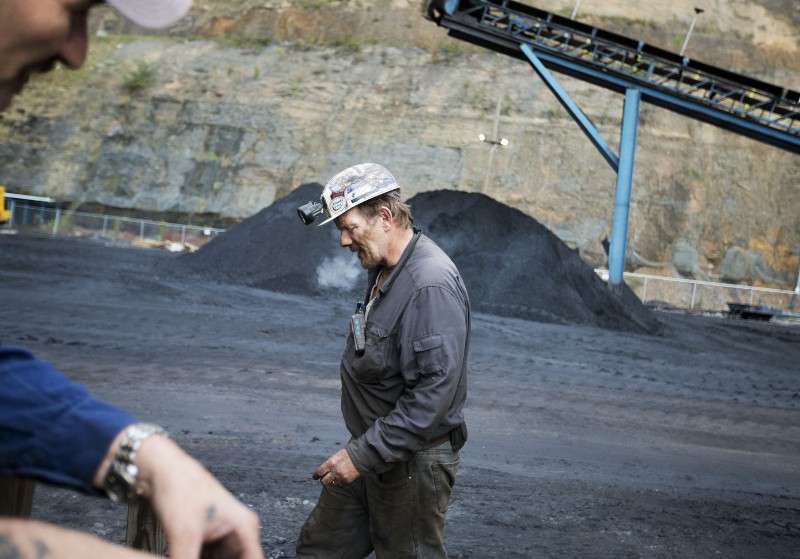 Foreman John Dillon, a coal miner of 39 years, walks past piles of coal at the Sewell “R” coal mine in Yukon, W.Va.