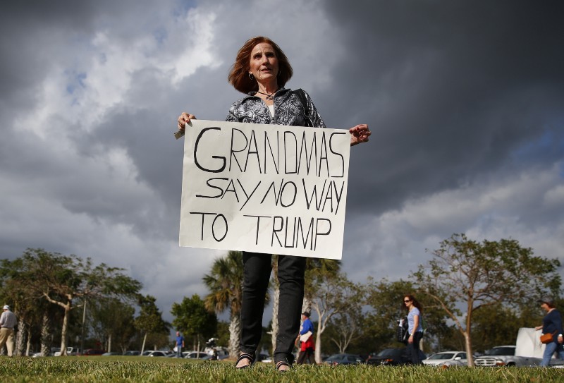 Mary Dickens holds a sign outside a Republican presidential candidate Donald Trump campaign rally in Boca Raton, Fla., Sunday, March 13, 2016. CREDIT: AP PHOTO/PAUL SANCYA