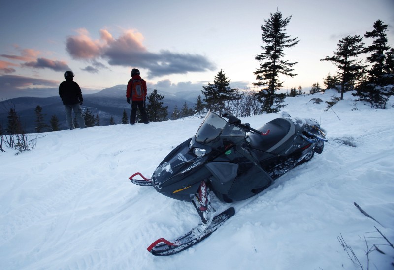 In this Jan. 28, 2011 photo, snowmobilers take in the scenery on a parcel of land sandwiched in between land owned by conservationist Roxanne Quimby in Township 5, Range 8, Maine. CREDIT: AP PHOTO/ROBERT F. BUKATY