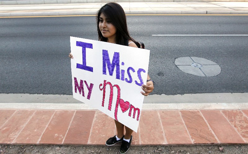 Cynthia Diaz, 17, quietly holds up a sign telling her story of her Mom’s deportation last year, as she joins dozens who rally in front of U.S. Immigration and Customs Enforcement building, a day after a portion of Arizona’s immigration law took effect, Wednesday, Sept. 19, 2012, in Phoenix. CREDIT: AP PHOTO/ROSS D. FRANKLIN