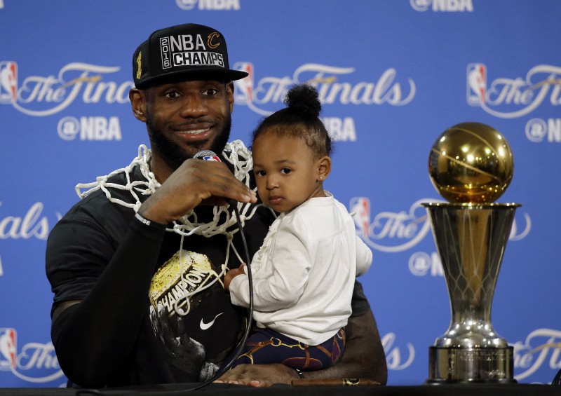 Cleveland Cavaliers’ LeBron James answers questions as he holds his daughter Zhuri during a post-game press conference after Game 7 of basketball’s NBA Finals Sunday, June 19, 2016, in Oakland, Calif. CREDIT: ERIC RISBERG, AP