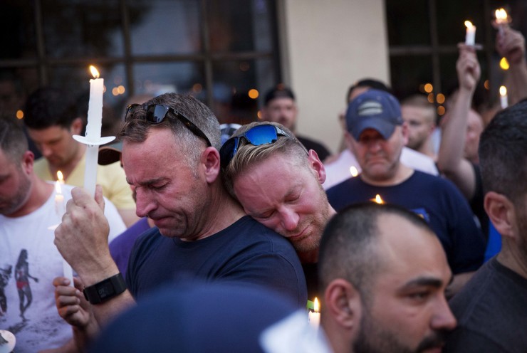 Paul Cox, right, leans on the shoulder of Brian Sullivan, as they observe a moment of silence during a vigil for a fatal shooting at an Orlando nightclub, Sunday, June 12, 2016, in Atlanta. CREDIT: AP Photo/David Goldman