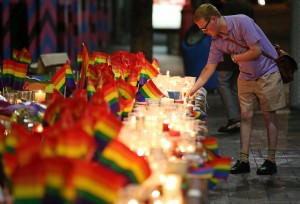 A man looks over an impromptu candle-lit memorial set up in Sydney, Monday, June 13, 2016 CREDIT: Rick Rycroft, AP Photo