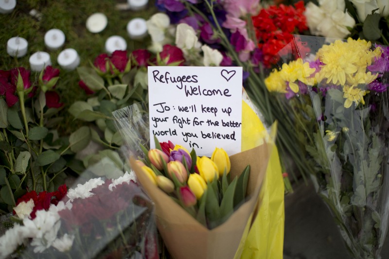 A message and floral tributes for Jo Cox, the 41-year-old British Member of Parliament shot to death yesterday in northern England, lie placed on Parliament Square outside the House of Parliament in London, Friday, June 17, 2016. CREDIT: AP PHOTO/MATT DUNHAM