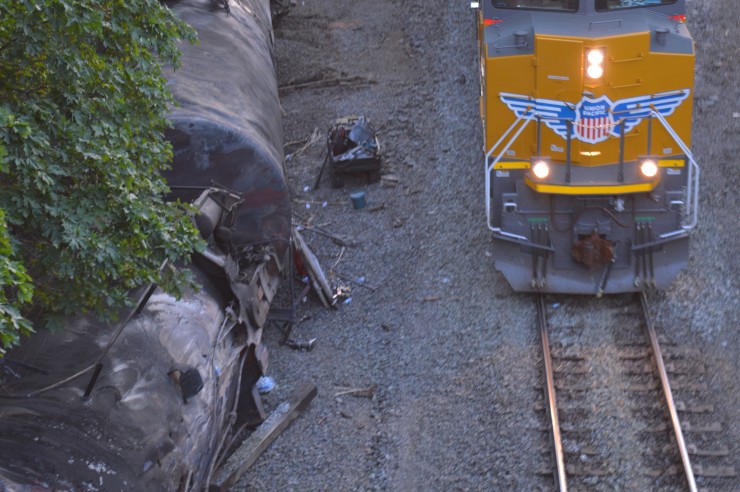 A Union Pacific train rolls through Mosier as derailed oil cars sit nearby. CREDIT: Columbia RiverKeeper