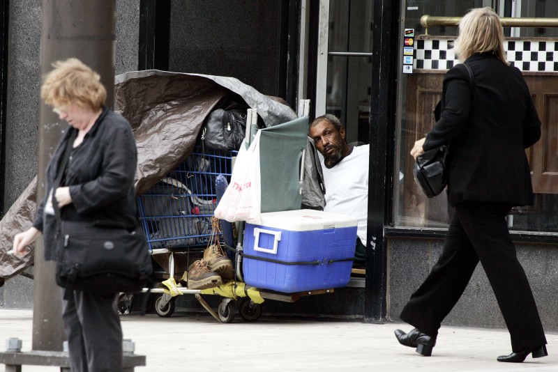 Tyrone Williams, 59, center, sits in an entryway with all his possessions as pedestrians walk by Wednesday, Aug. 31, 2005, in Cleveland. CREDIT: AP PHOTO/TONY DEJAK