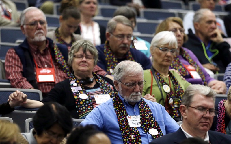 Methodists wear multi-colored scarves in support of LGBT rights at the United Methodist Church’s General Conference in May. CREDIT: AP PHOTO/DON RYAN