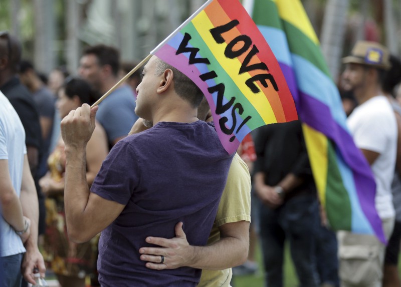 Juan Mantilla, 42, of Miami Beach, Fla., left, stands with his partner during a vigil in memory of the victims of the Orlando mass shooting, Sunday, June 12, 2016, in Miami Beach, Fla. CREDIT: AP PHOTO/LYNNE SLADKY