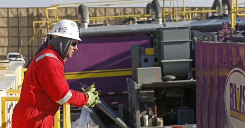 In this March 25, 2014 photo, a worker watches over a hydraulic fracturing operation at an Encana Corp. oil well near Mead, Colo. In the background is a tall canvas wall around the perimeter of the extraction site, which mitigates noise, light and dust coming from the operation during the drilling and completion phase, which generally takes a few weeks. CREDIT: AP PHOTO/BRENNAN LINSLEY