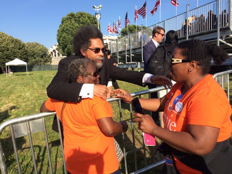 April Washington, right, hugs Dr. Cornell West at Sanders’ Washington, D.C. rally CREDIT: Alice Ollstein