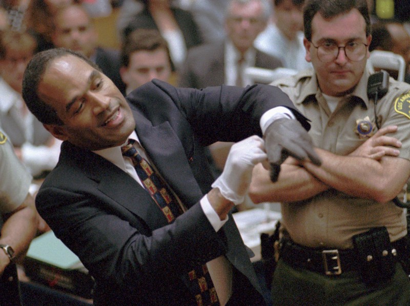 FILE — In this June 15, 1995, file photo, murder defendant, O.J. Simpson grimaces as he tries on one of the leather gloves prosecutors say he wore the night his ex-wife Nicole Brown Simpson and Ron Goldman were murdered, during the Simpson double-murder trial in Los Angeles. CREDIT: SAM MIRKOVICH, AP