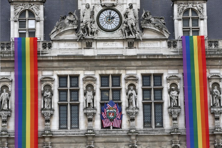 American flags and a rainbow banners hang at the Paris City Hall Monday, June 13, 2016 in Paris. CREDIT: AP Photo/Christophe Ena