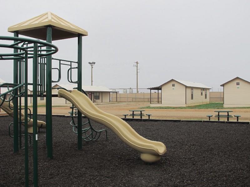 A playground surrounded by cottages that will house immigrants at a new family immigration detention center in Dilley, Texas, on Monday, Dec. 15, 2014. CREDIT: AP PHOTO/WILL WEISSERT