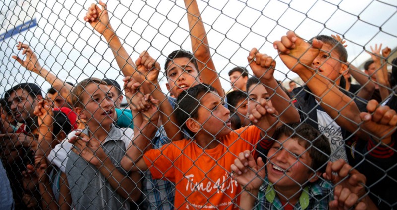 Syrian refugee children chant slogans behind a fence at the Nizip refugee camp in Gaziantep province, southeastern Turkey, following a visit by German Chancellor Angela Merkel and top European Union officials, Saturday, April 23, 2016 CREDIT: AP PHOTO/LEFTERIS PITARAKIS