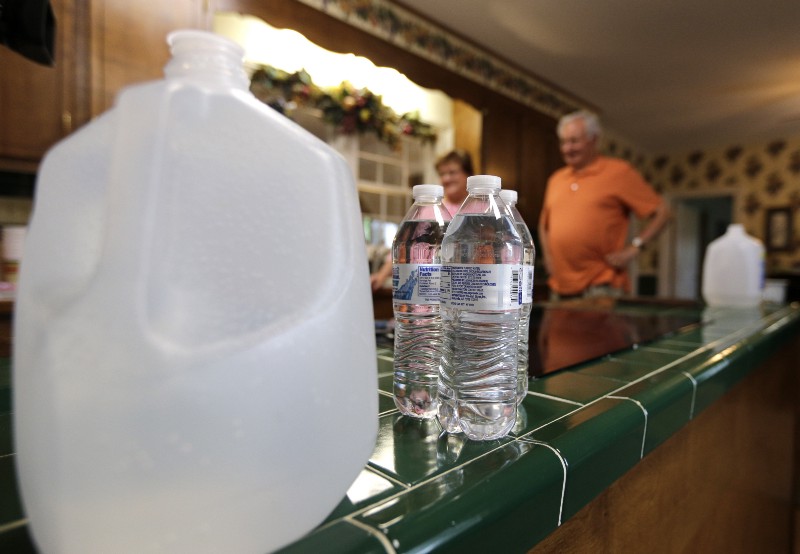 In this April 25, 2014 photo, bottled water rests on the kitchen counter of Ron and Joanne Thomas’ home in Dukeville, N.C. The well at their family farm, which is next to a Duke Energy ash pond, is contaminated according to samples taken in March and April by the Waterkeeper Alliance and tested at two accredited independent labs. Under state law, North Carolina officials could have required Duke Energy to clean up the groundwater in Dukeville to prevent possible contamination of residential supplies. CREDIT: AP PHOTO/CHUCK BURTON