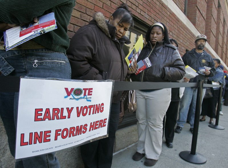 Voters line up outside the Hamilton County Board of Elections for early voting in Cincinnati. CREDIT: AP PHOTO/AL BEHRMAN