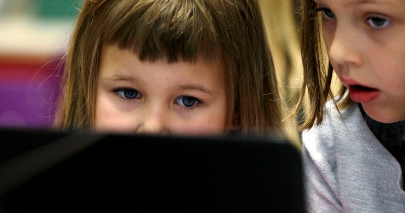 Kindergartner Kaidyance Harris, left, works on a computer with second grader Annabelle Davis at at Marshall Elementary School in Marysville, Wash, Nov. 4, 2015. CREDIT: AP PHOTO/RICK BOWMER
