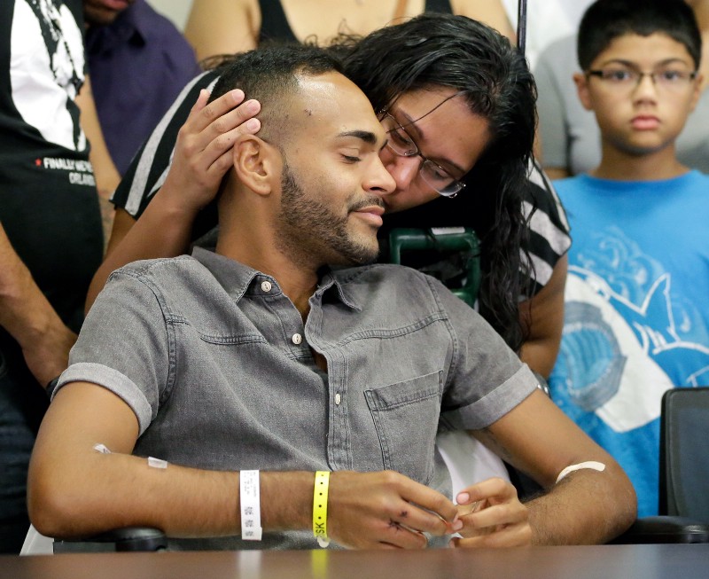 Angel Colon, a victim of the Pulse nightclub shooting, is kissed by his sister while attending a news conference at the Orlando Regional Medical Center Tuesday, June 14, 2016, in Orlando, Fla. CREDIT: JOHN RAOUX, AP PHOTO