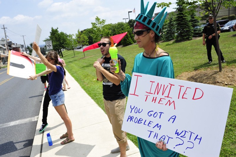Members of the Industrial Workers of the World Lehigh Valley branch rally outside the KidsPeace Broadway campus in support of the unaccompanied immigrant children who are temporarily housed there. CREDIT: AP PHOTO/CHRIS POST