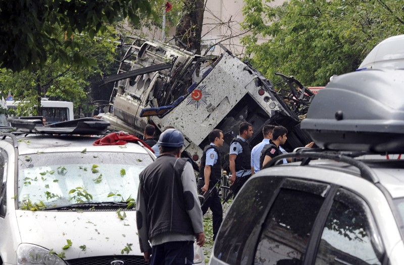 Turkish security officials and firefighters work at the explosion site after a bus carrying police was struck by a bomb in Istanbul, Tuesday, June 7, 2016. CREDIT: DHA VIA AP