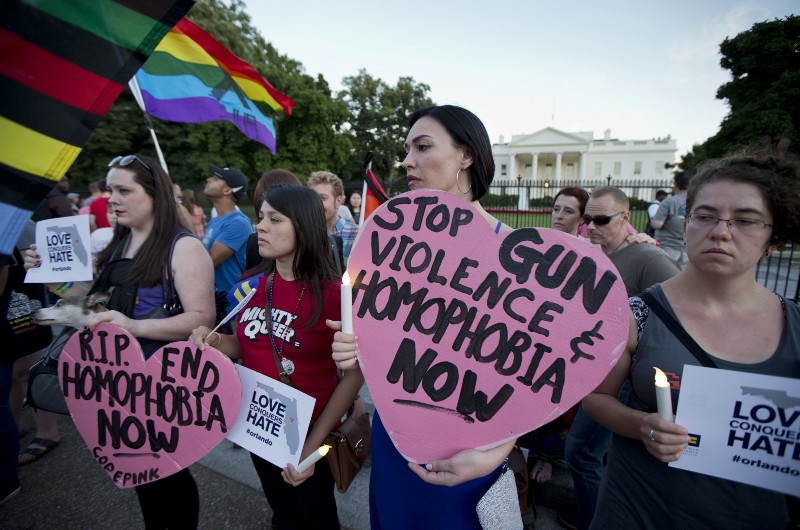 Rachel Henry, from left, Selene Arciga, Nicolette Gullickson, Joanna Lamstein join members and supporters of the LGBT as they gather for a candlelight vigil in front of the White House in Washington, Sunday, June 12, 2016, in support for the victims and their families and friends, who were killed and injured in a massacre at an Orlando nightclub. CREDIT: AP PHOTO/MANUEL BALCE CENETA