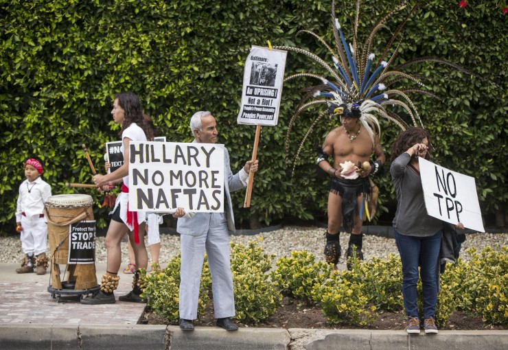 Los Angeles community members wait for Hillary Rodham Clinton’s motorcade as they oppose the Trans-Pacific Partnership (TPP) and Trade Promotion Authority (TPA) known as The Fast Track, in Beverly Hills, Calif., Thursday, May 7, 2015. CREDIT: AP Photo/Damian Dovarganes