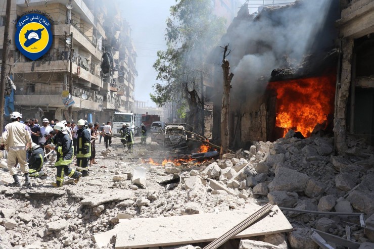This photo taken on June 8, 2016 provided by the Syrian Civil Defense Directorate in Liberated Province of Aleppo, which has been authenticated based on its contents and other AP reporting, shows Syrian civil defense workers, left, gather at a street which attacked by warplanes, in Aleppo, Syria. CREDIT: Civil Defense Directorate in Liberated Province of Aleppo via AP