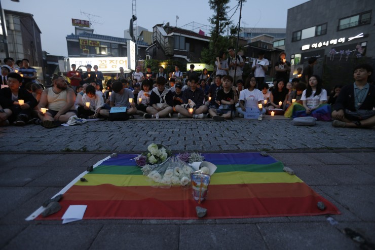 People hold candles during a vigil to pay tribute to the victims of the Orlando shooting in Seoul, South Korea, Monday, June 13, 2016 CREDIT: AP Photo/Ahn Young-joon