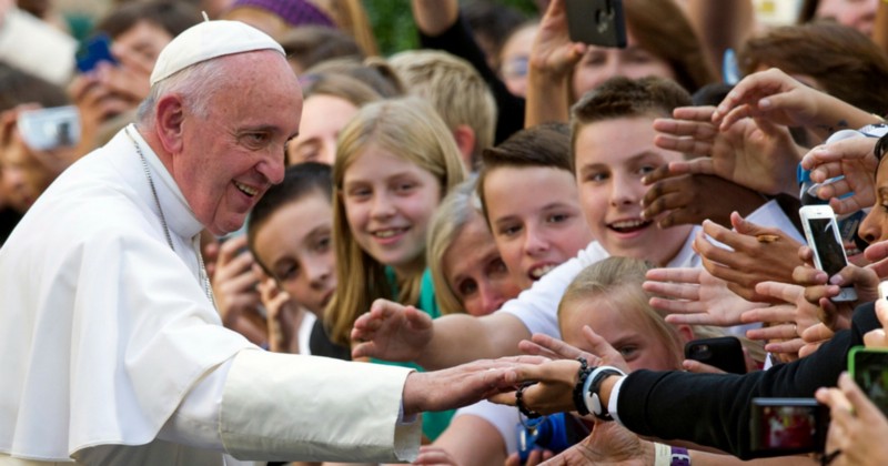 In this Sept., 24, 2015 file photo, Pope Francis shakes hands with school children as he departs the Apostolic Nunciature, the Vatican’s diplomatic mission in the heart of Washington, en route Andrews Air Force Base. The book, “Dear Pope Francis,” with questions posed for the pope from 30 children from around the globe is out March 1, 2016, from Loyola Press in Chicago. CREDIT: AP PHOTO/CLIFF OWEN