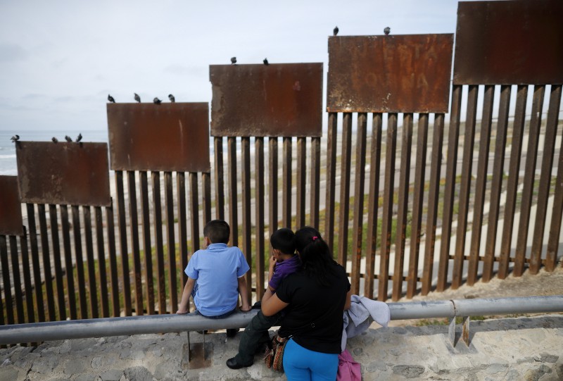 A family looks towards metal bars marking the United States border where it meets the Pacific Ocean Wednesday, March 2, 2016, in Tijuana, Mexico. Former Mexican President Vicente Fox on Wednesday stood by his comparison of Donald Trump to Adolf Hitler, saying the Republican presidential front-runner believes in the white supremacy. Fox is calling on Americans to wake up from this Republican nightmare. He made the remarks Wednesday in an interview taped for Fox News Channels Hannity. Trump has angered many Mexicans for his campaign rhetoric denigrating some immigrants as “rapists” who bring crime and drugs to the United States, and his promise to build a wall along the entire US-Mexico border. (AP Photo/Gregory Bull) CREDIT: AP PHOTO/GREGORY BULL
