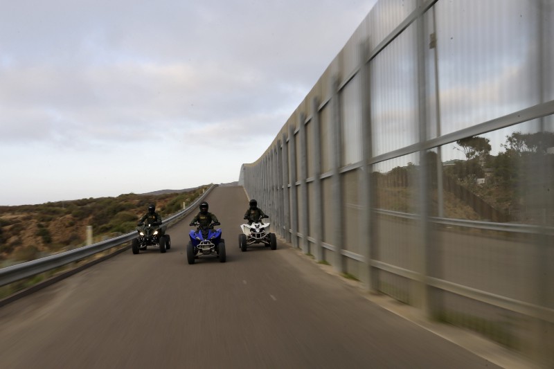 In this Wednesday, June 22, 2016 photo, Border Patrol agents ride all-terrain vehicles along a secondary fence separating Tijuana, Mexico, right, and San Diego in San Diego. CREDIT: AP PHOTO/GREGORY BULL