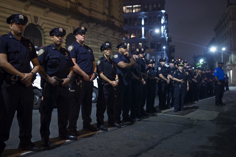 Police officers stand guard as they watch protesters in the Brooklyn borough of New York, Friday, July 8, 2016. CREDIT: AP PHOTO/ANDRES KUDACKI