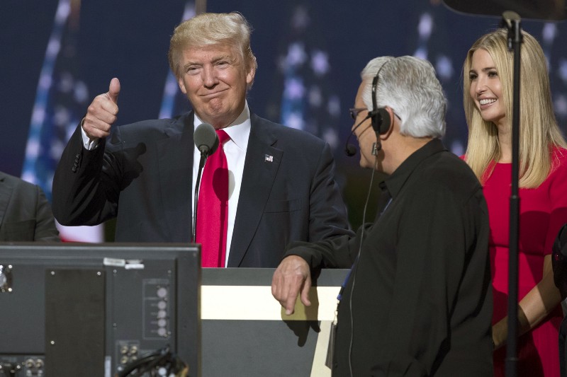 Republican presidential candidate Donald Trump, center, gives a thumbs up as he talks with production crew during a walk through in preparation for his speech at the Republican National Convention, Thursday, July 21, 2016, in Cleveland. At right is is daughter Ivanka. CREDIT: AP PHOTO/EVAN VUCCI
