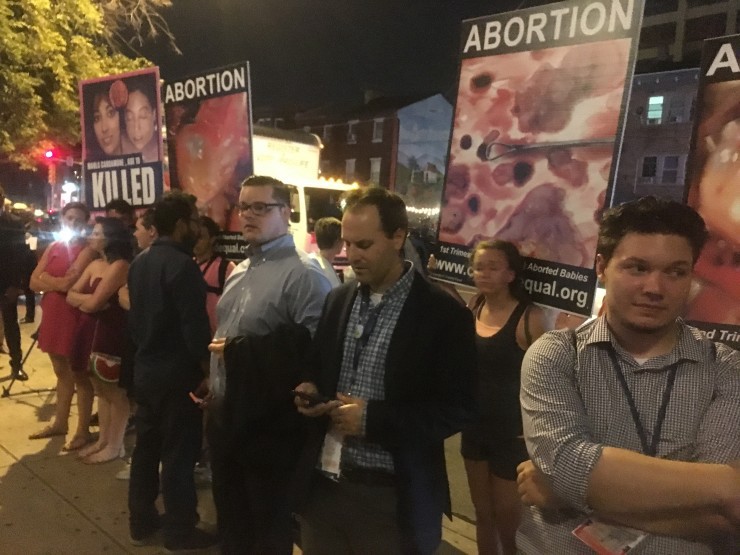 Men form a human wall between Planned Parenthood supporters and anti-choice protesters. CREDIT: Kira Lerner