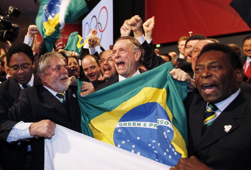 Brazil’s former President Luiz Inacio Lula da Silva, left, Rio 2016 bid President Carlos Arthur Nuzman, center, and Brazilian soccer great Pele, right, celebrate with their delegation after Rio de Janeiro won the bid to host the 2016 Summer Olympic. CREDIT: AP Photo/Charles Dharapak, Pool